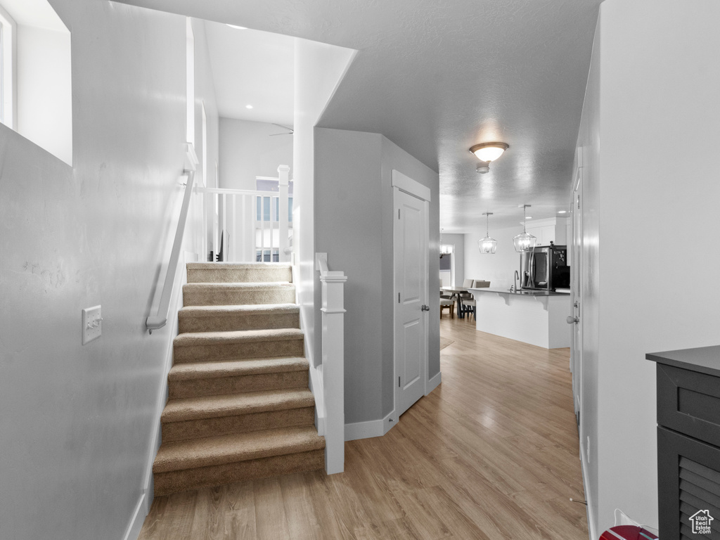 Stairs with wood finished floors and baseboards