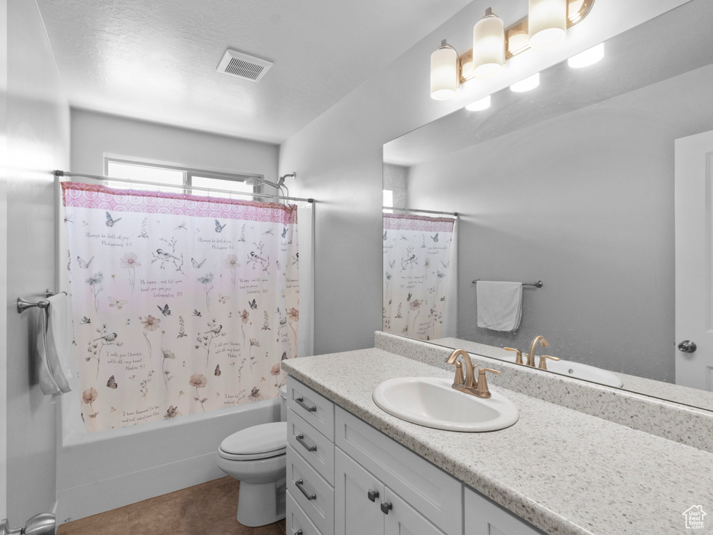 Bathroom with toilet, shower / tub combo, vanity, and tile patterned floors