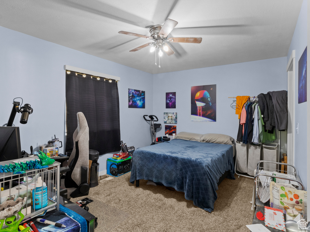 Carpeted bedroom featuring ceiling fan