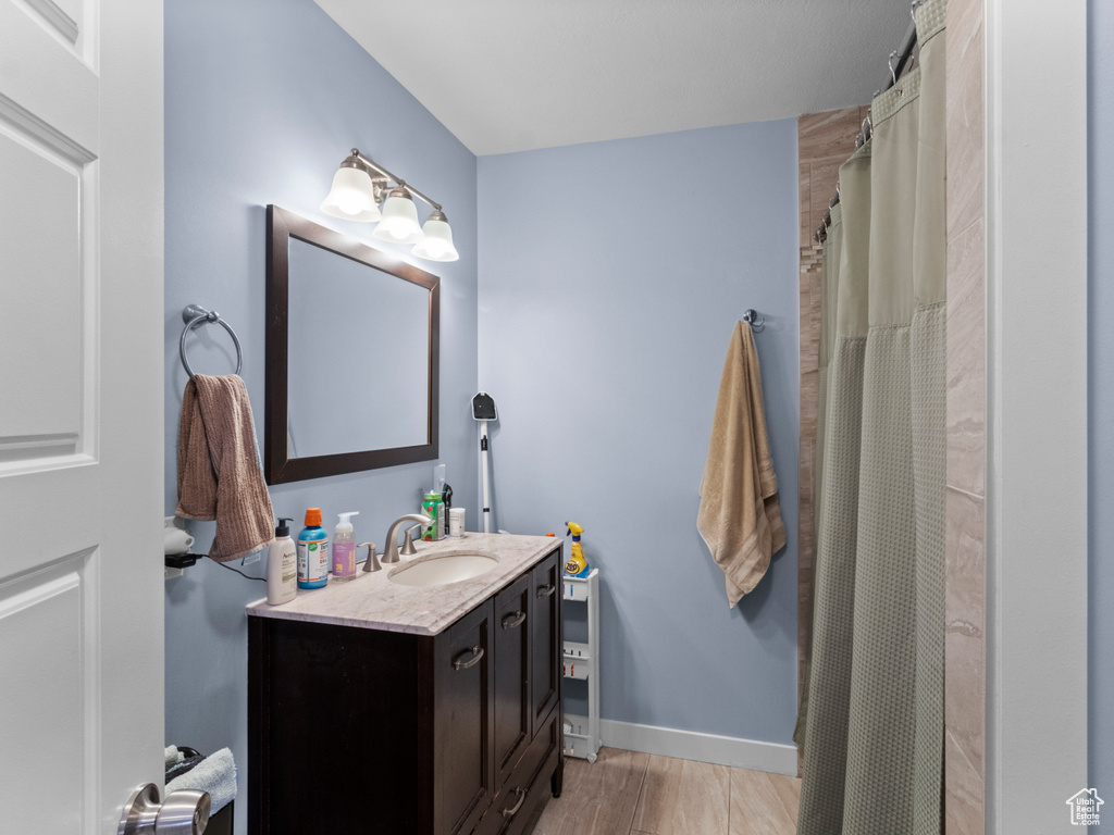 Full bath with vanity and wood finished floors