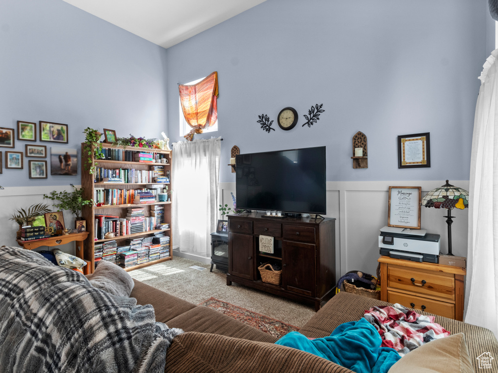 Living area with a wainscoted wall and carpet floors