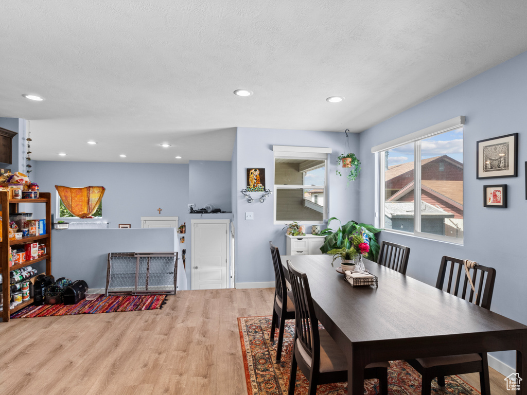 Dining area with light wood-style flooring, recessed lighting, and baseboards