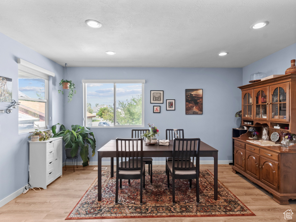 Dining area with light wood-style floors, recessed lighting, and baseboards