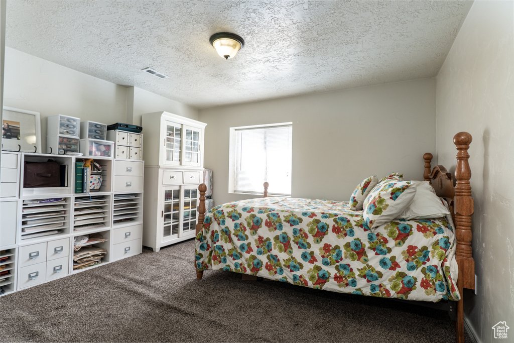 Carpeted bedroom with a textured ceiling