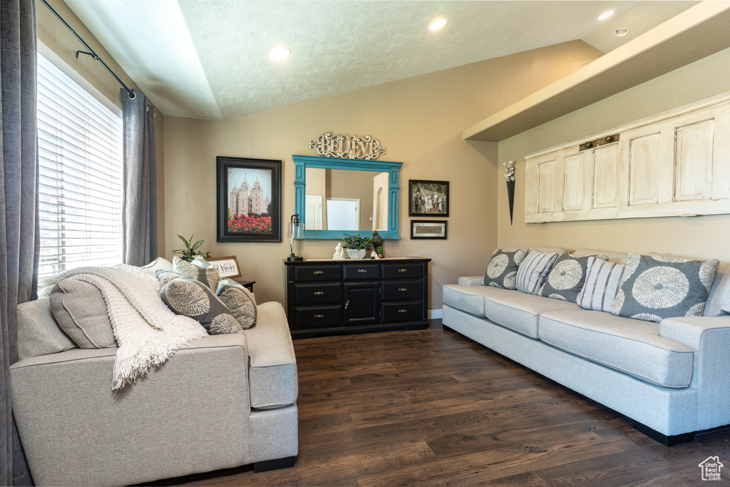 Living room featuring lofted ceiling, plenty of natural light, recessed lighting, and dark wood-style flooring