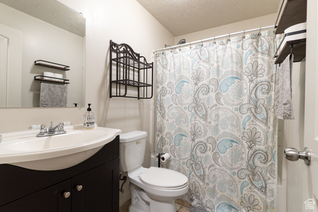 Bathroom with vanity, toilet, and a textured ceiling