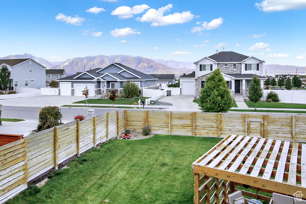View of yard featuring a residential view, a mountain view, and driveway