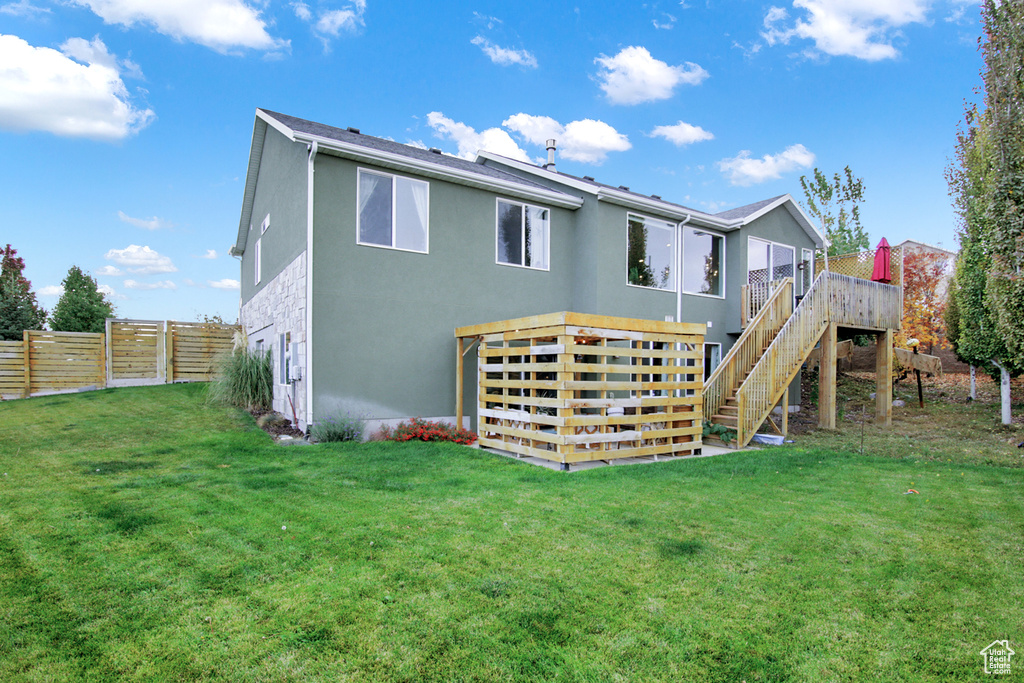Back of house with stucco siding, stairway, and a deck