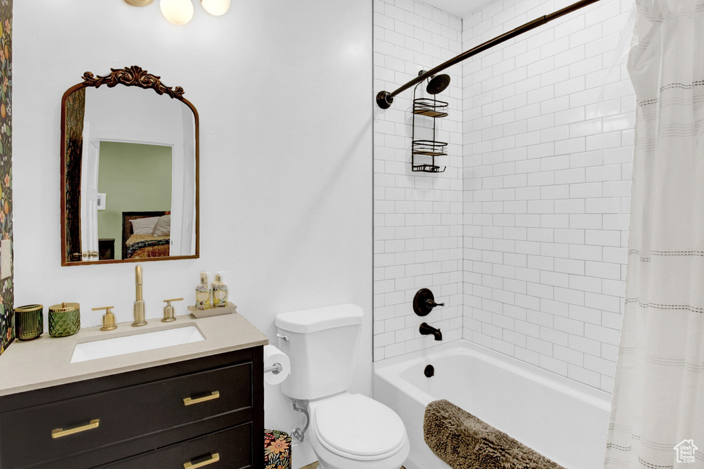Full bathroom with vanity, toilet, shower / bath combination with curtain, and ensuite bathroom