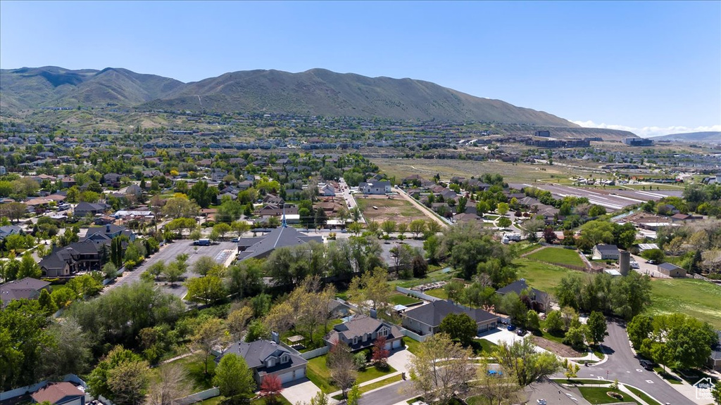 Aerial view of property and surrounding area with a mountainous background and nearby suburban area