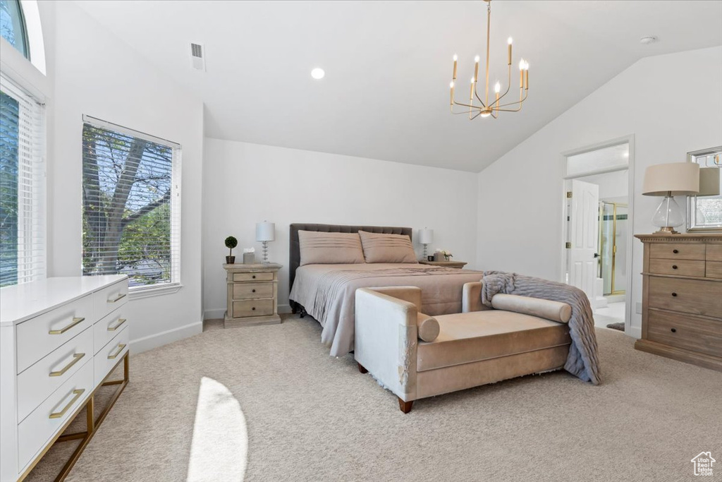 Bedroom with light carpet, lofted ceiling, a chandelier, baseboards, and ensuite bath