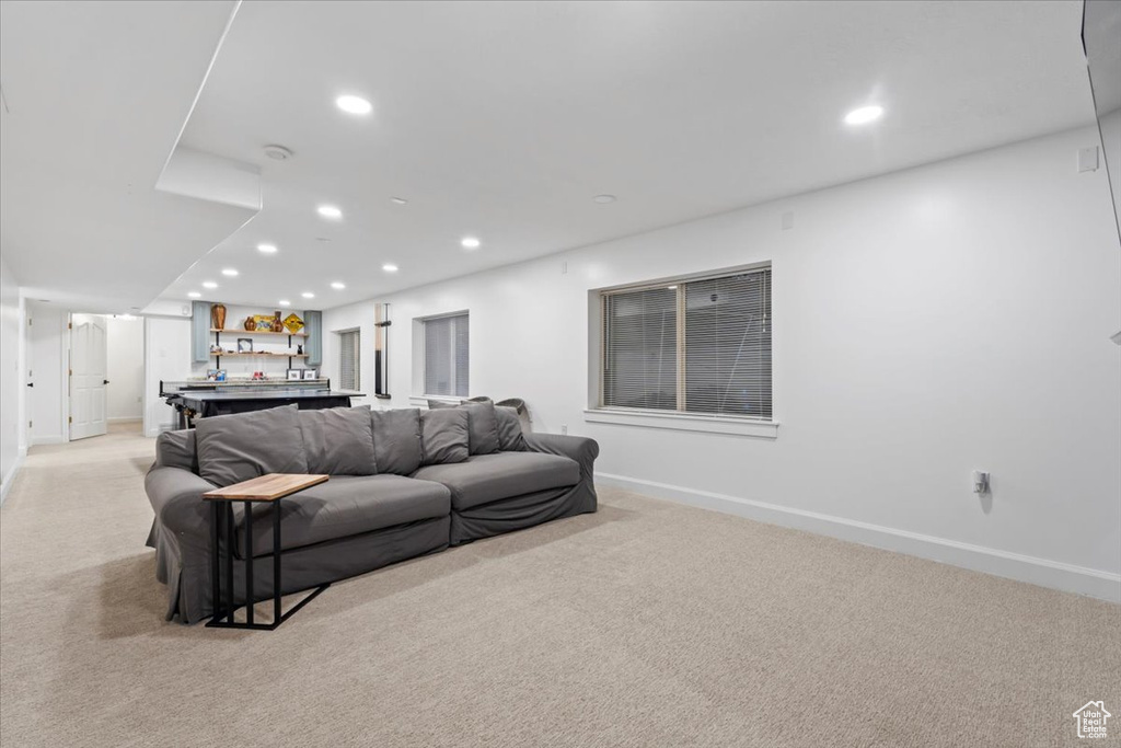 Living area featuring light colored carpet, baseboards, and recessed lighting