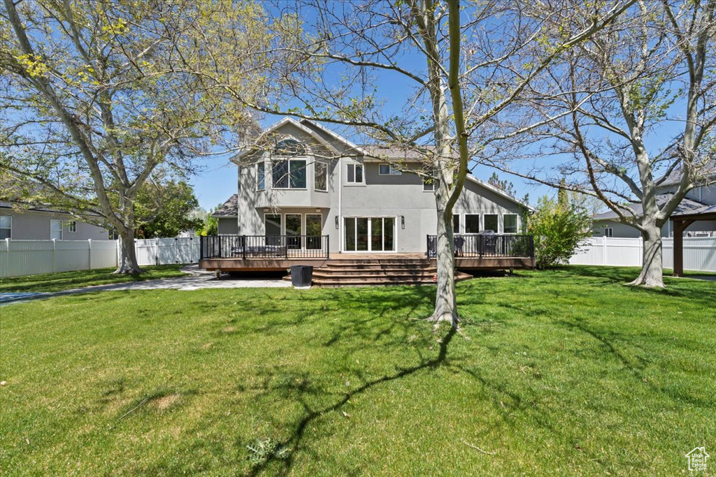 Back of property featuring a wooden deck and stucco siding
