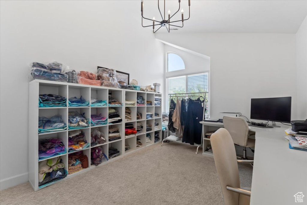 Carpeted home office with a chandelier and high vaulted ceiling