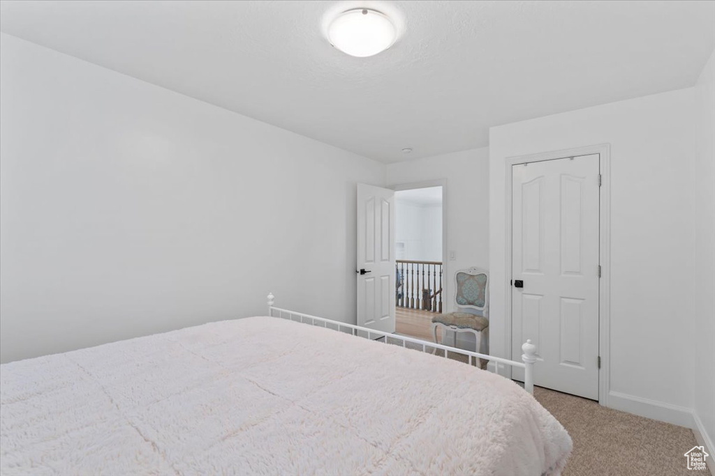 Bedroom featuring light carpet and baseboards
