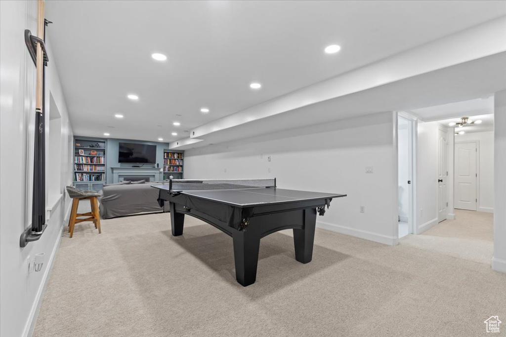 Recreation room featuring light colored carpet, baseboards, recessed lighting, and a fireplace