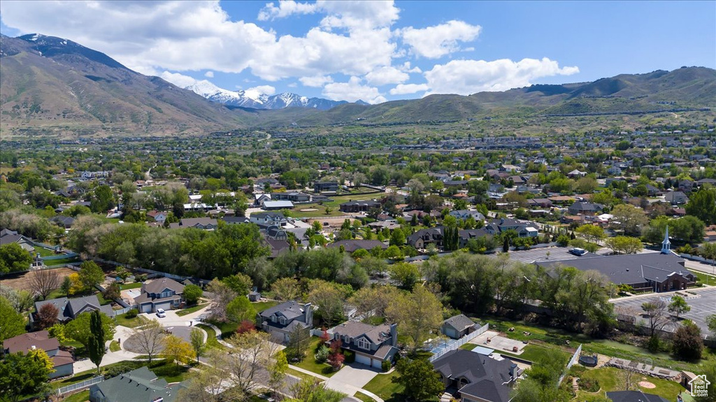 Aerial view of property's location with nearby suburban area and a mountainous background