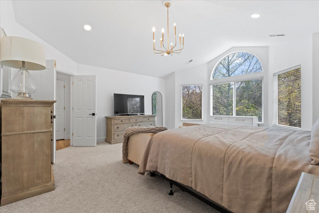 Bedroom featuring lofted ceiling, light colored carpet, a chandelier, and recessed lighting
