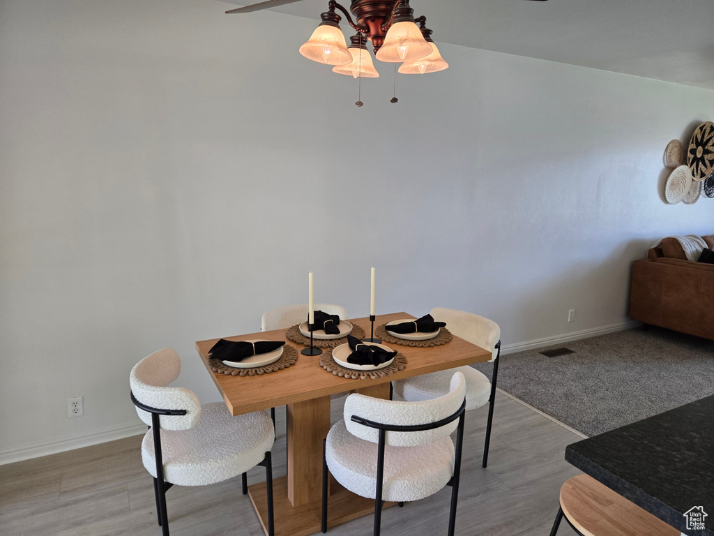 Dining room featuring baseboards, light wood finished floors, and a ceiling fan