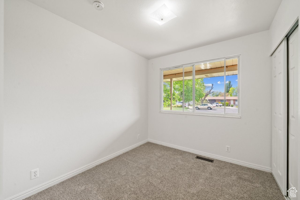 Unfurnished bedroom with carpet floors, baseboards, and a closet