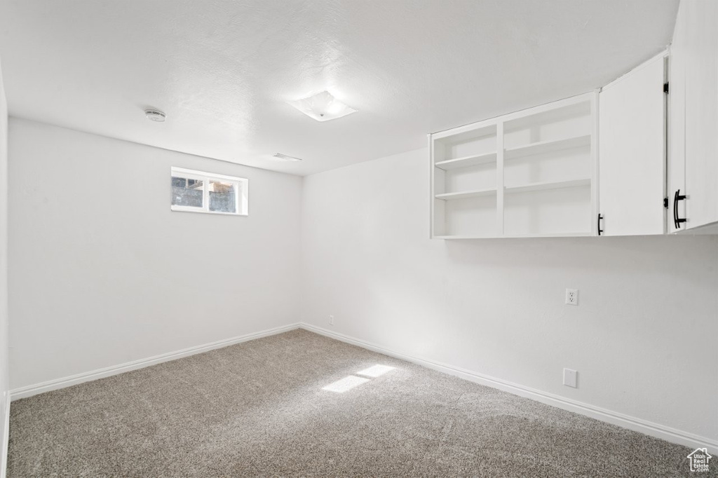 Carpeted empty room with baseboards