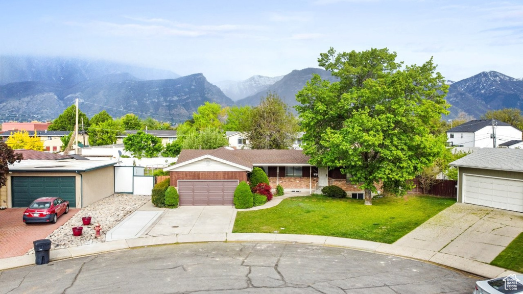 View of front of home featuring a mountain view, a garage, and driveway