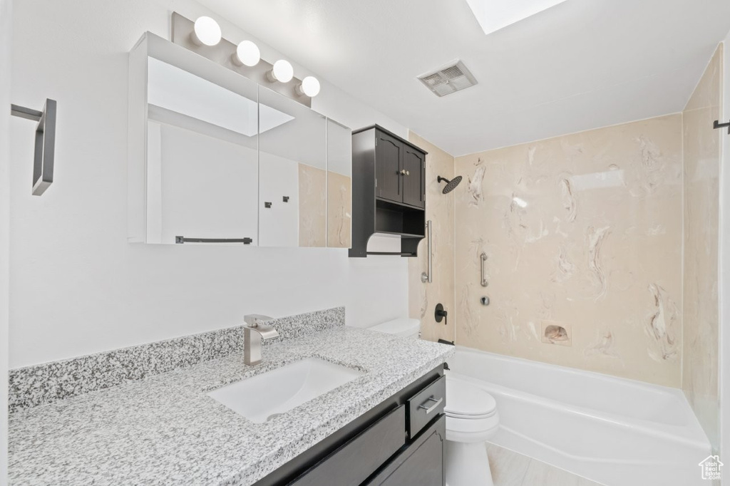 Full bathroom with toilet,  shower combination, and vanity