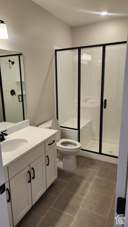 Bathroom with a shower stall, toilet, vanity, tile patterned floors, and recessed lighting