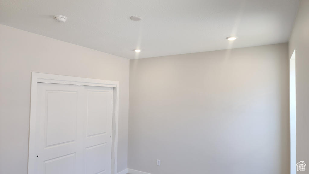 Unfurnished room featuring baseboards, recessed lighting, and a smoke detector