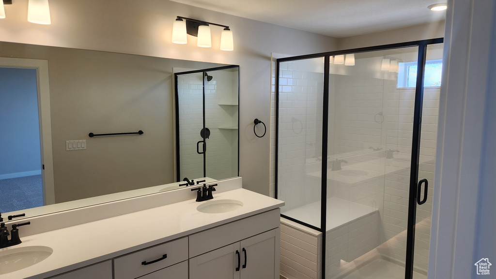Full bathroom with double vanity and a stall shower
