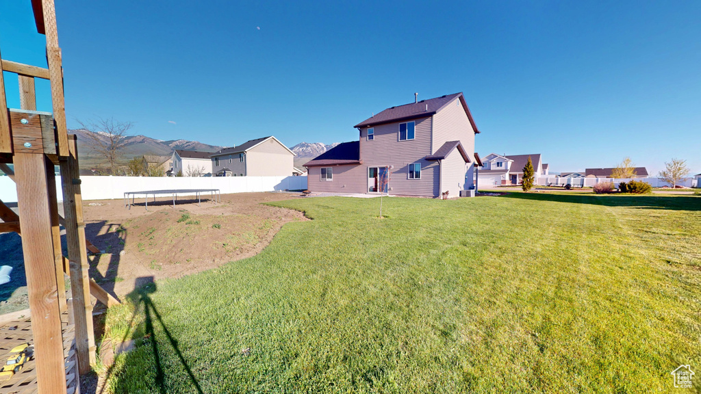 View of yard with a trampoline and a residential view