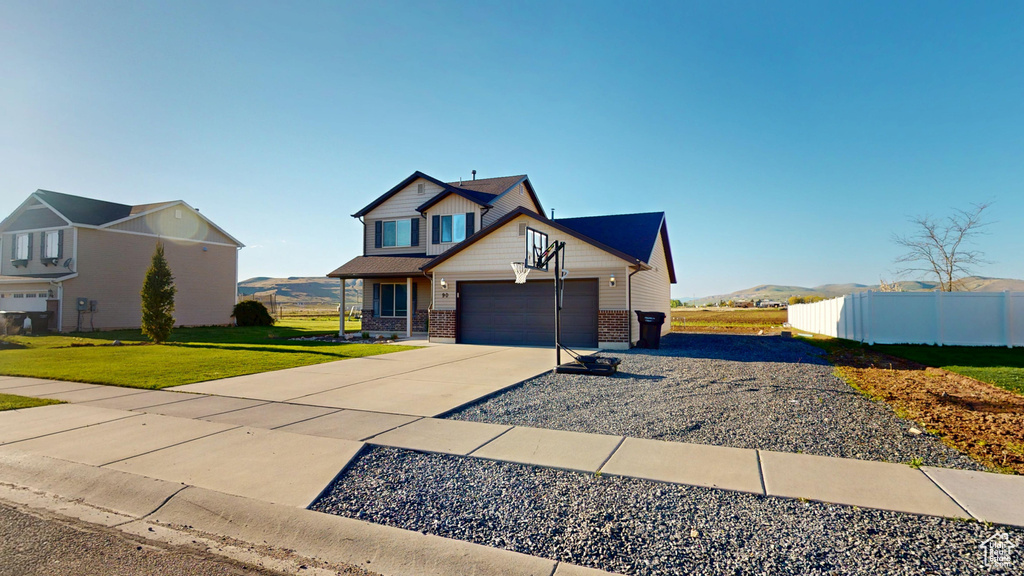 View of front of home featuring concrete driveway, brick siding, and a garage