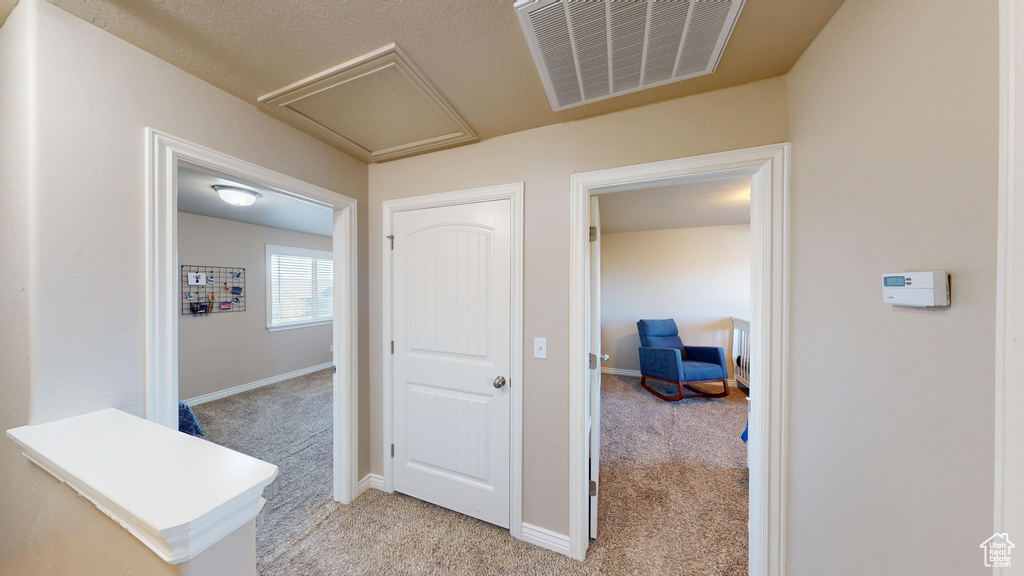 Corridor featuring light carpet and baseboards