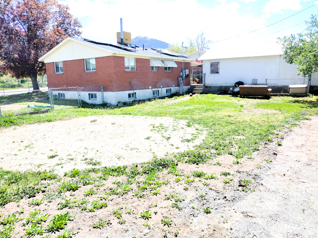 Rear view of house featuring fence and brick siding