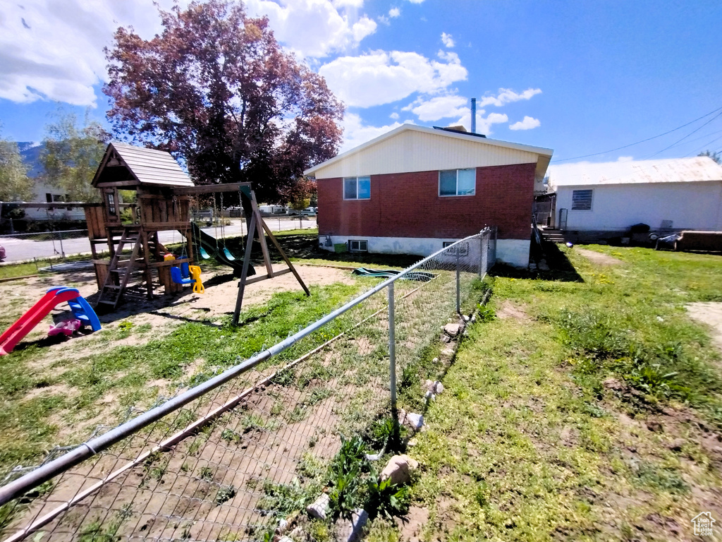 View of side of property with a playground and brick siding