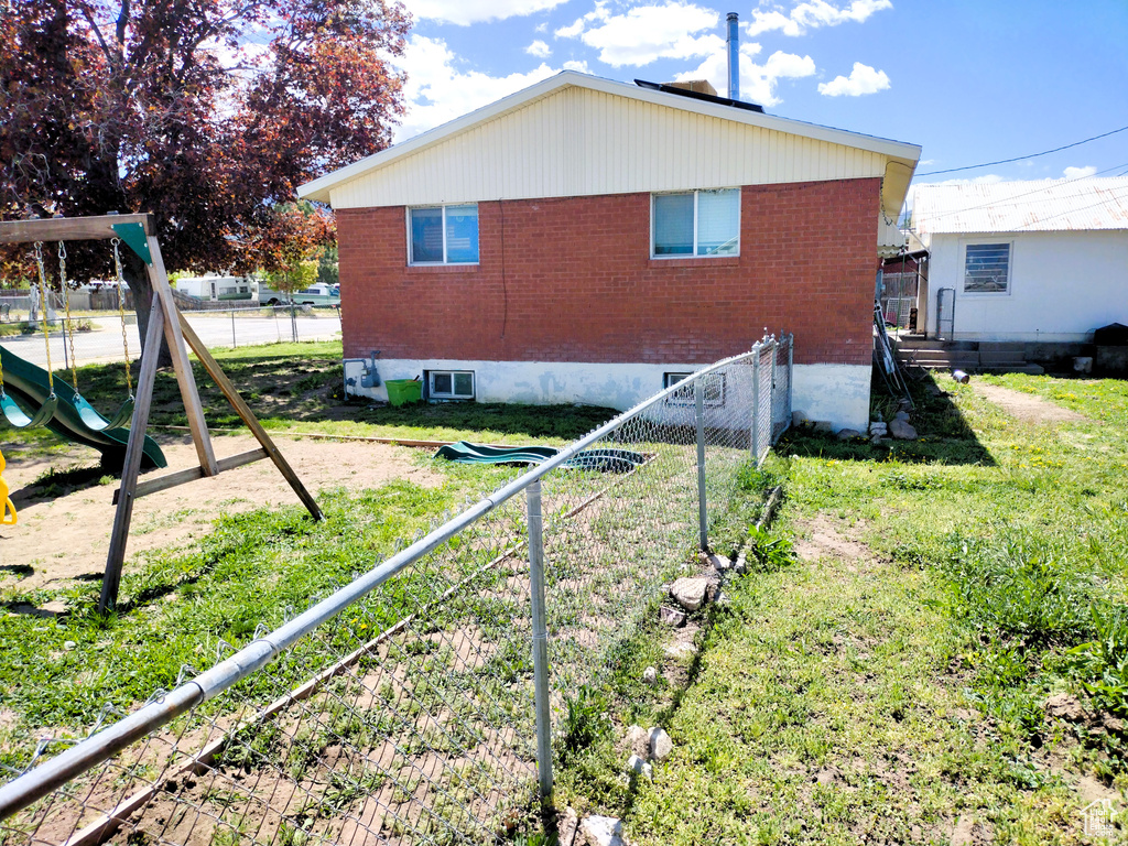 Back of property with brick siding and a playground