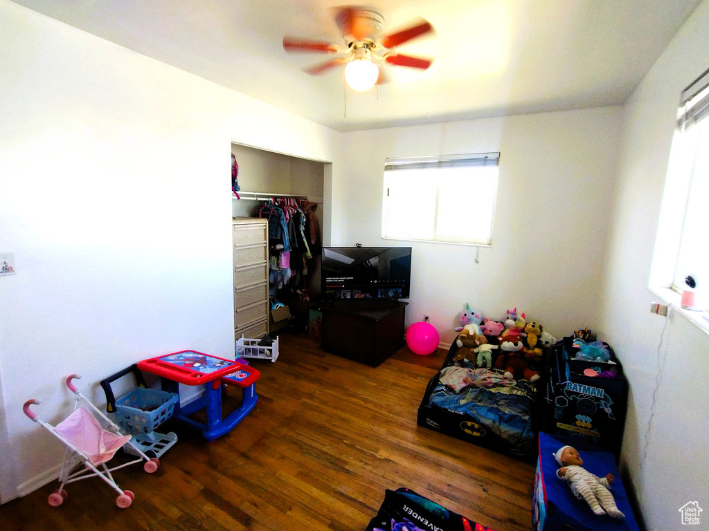 Recreation room with a ceiling fan and wood finished floors