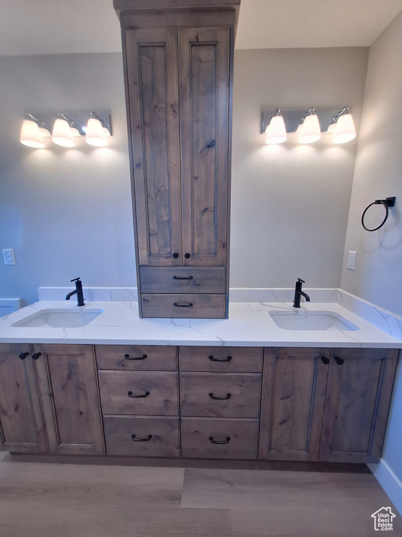 Full bathroom with double vanity and wood finished floors