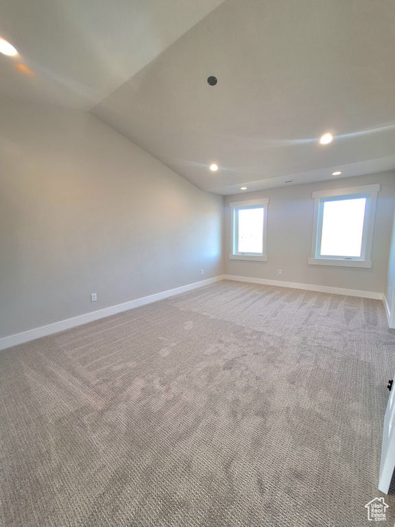 Unfurnished room featuring baseboards, recessed lighting, carpet floors, and lofted ceiling