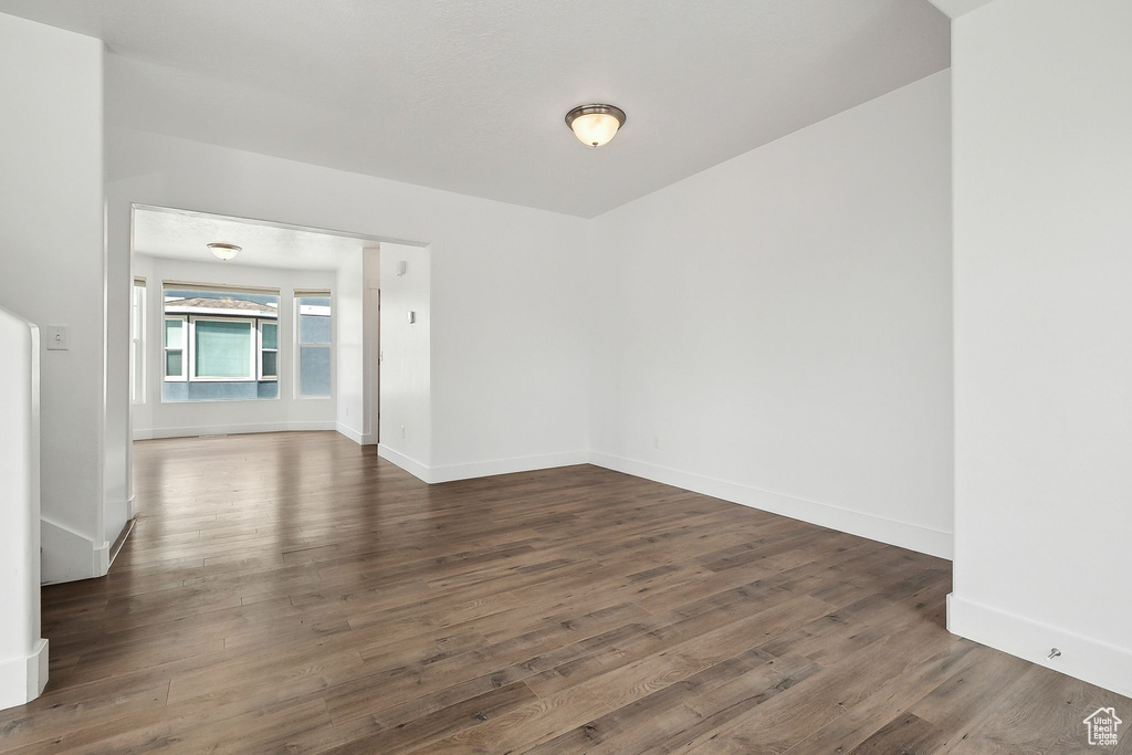 Empty room with dark wood-style flooring and baseboards
