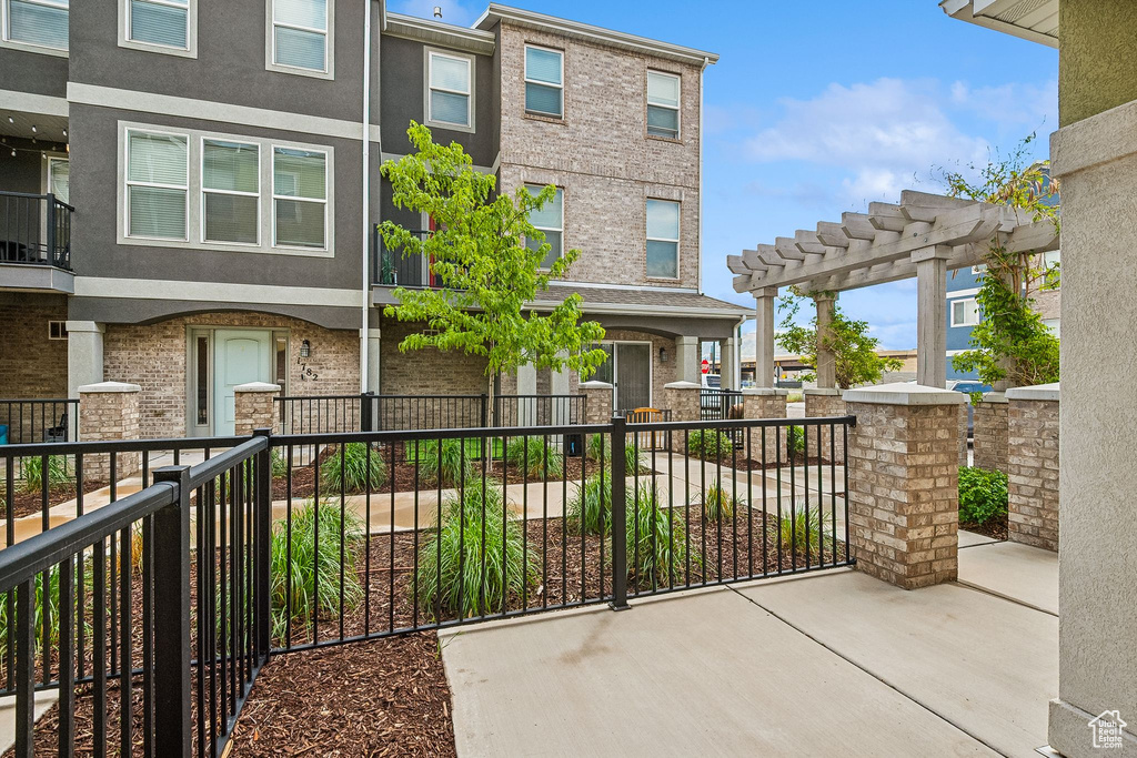 View of front of home featuring stucco siding and a pergola