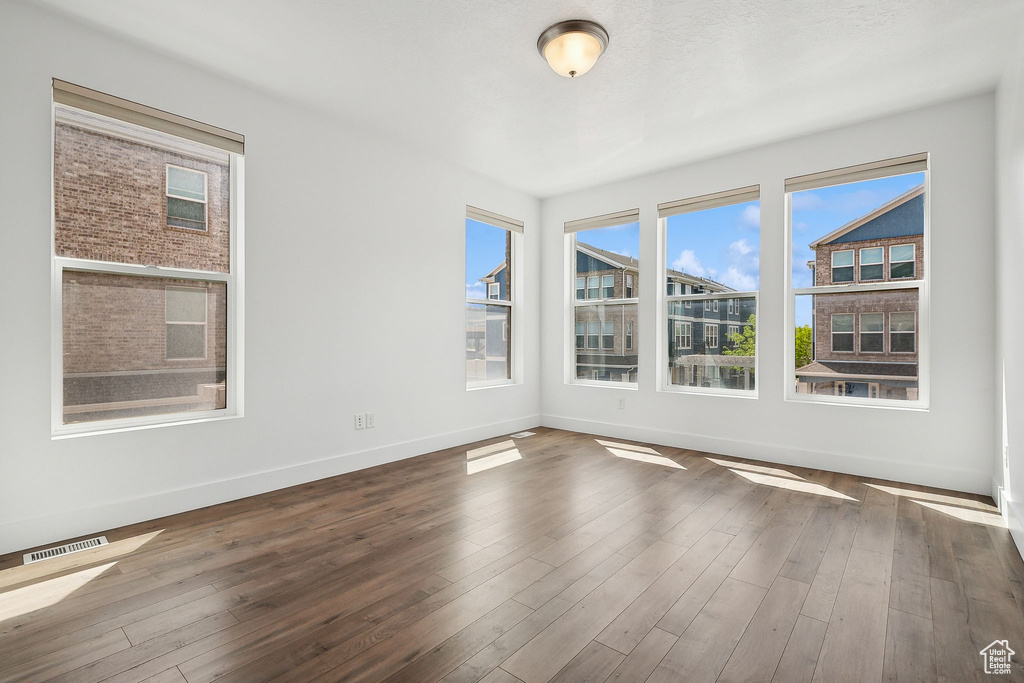 Spare room with baseboards and dark wood finished floors