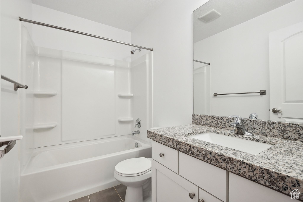 Bathroom featuring toilet, vanity, shower / tub combination, and tile patterned flooring