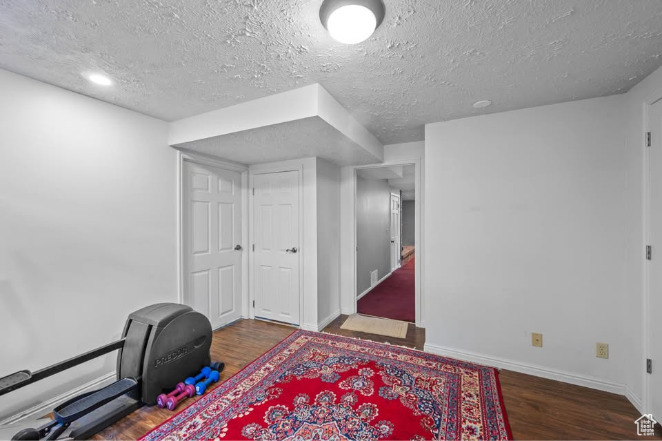 Office area featuring wood finished floors, baseboards, and a textured ceiling