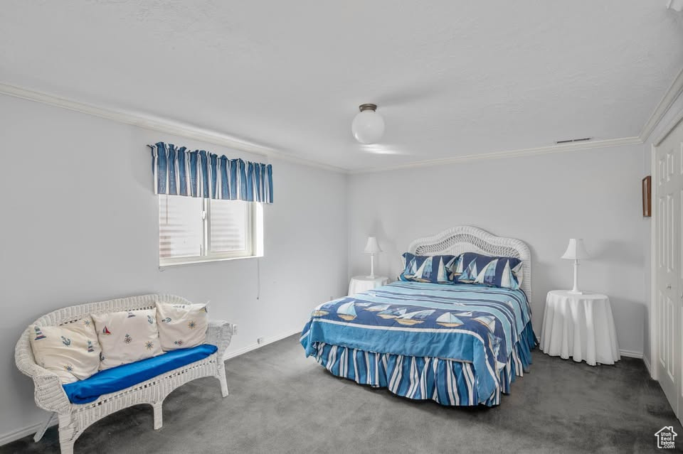 Bedroom with ornamental molding, carpet floors, and baseboards