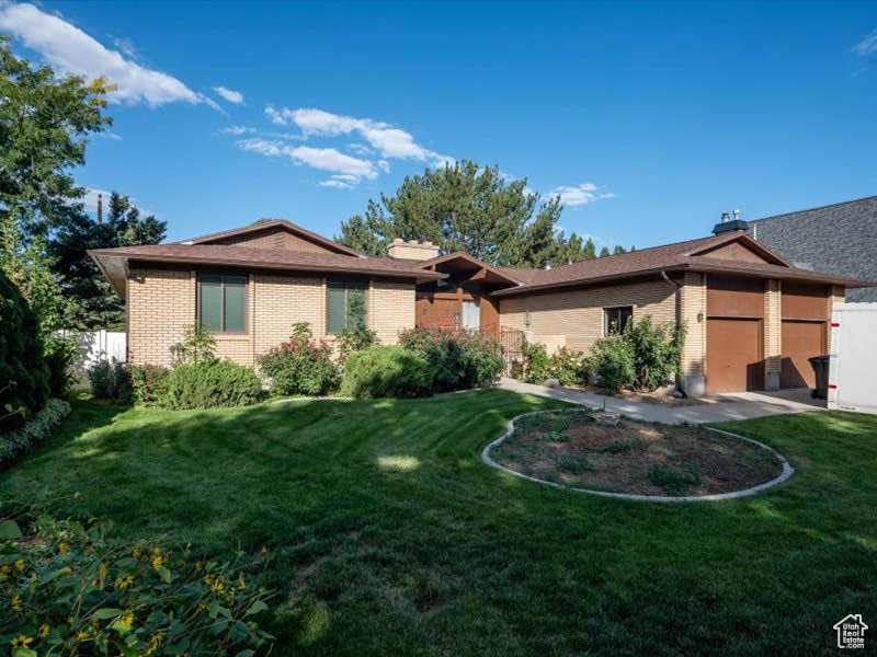 View of front of property featuring a garage and brick siding