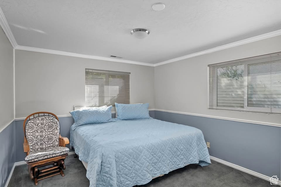 Carpeted bedroom featuring ornamental molding and baseboards