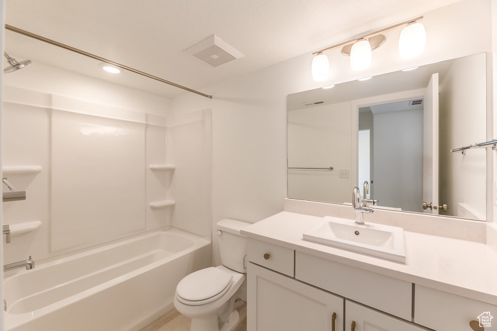 Full bath featuring toilet, vanity, bathing tub / shower combination, and recessed lighting
