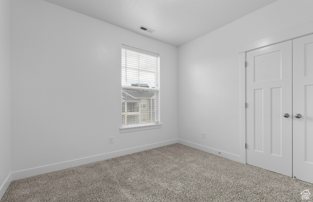 Unfurnished bedroom with carpet flooring, baseboards, and a closet