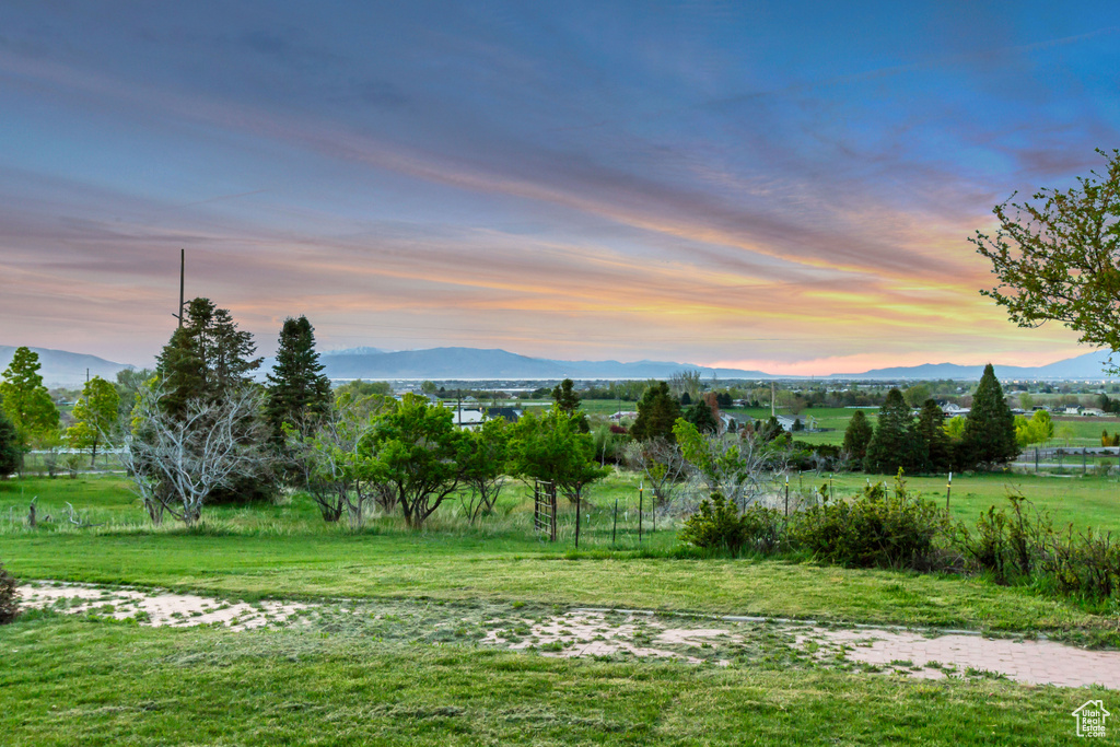 Yard at dusk featuring a view of rural / pastoral area and a mountain view